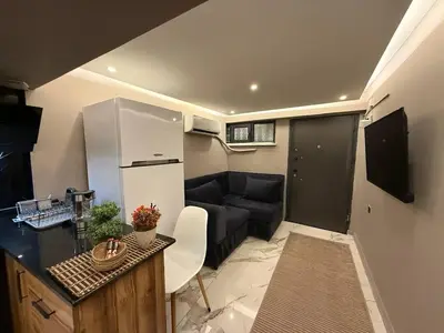 a small kitchen and living room with a couch at Cozy 1BR Basement Apartment Close to Metro in Istanbul