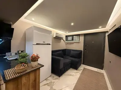 a small living room with a couch and a kitchen at Cozy 1BR Basement Apartment Close to Metro in Istanbul