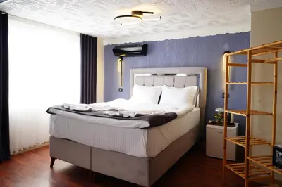a bedroom with a white bed with a blue wall at the apart galata in Istanbul