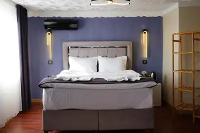 a bedroom with a bed with a blue wall at the apart galata in Istanbul
