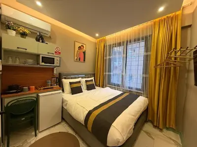 a bedroom with a bed and a desk and a window at Warm cozy studio 8 min by metro station in Istanbul