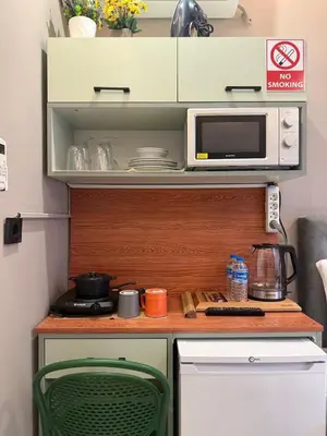 a small kitchen with a microwave and a stove at Warm cozy studio 8 min by metro station in Istanbul