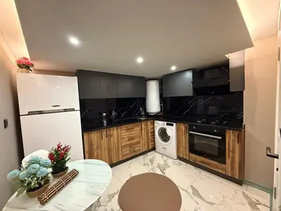 a kitchen with a white refrigerator and a table at Cozy duplex with a private terrace near the metro in Istanbul
