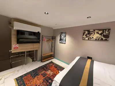 a bedroom with a bed and a tv on the wall at Cozy duplex with a private terrace near the metro in Istanbul