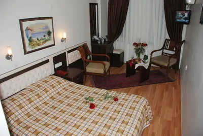 a hotel room with a bed with a plaid blanket at Hotel Grand Mark in Istanbul