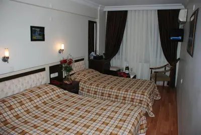 a hotel room with two beds and a chair at Hotel Grand Mark in Istanbul