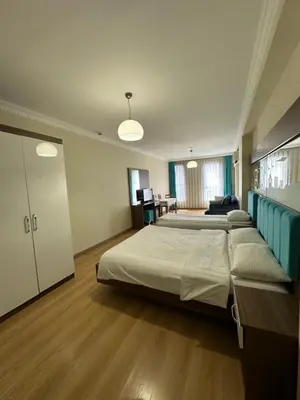 a large bedroom with two beds and a desk at Kupeli Hotel in Istanbul