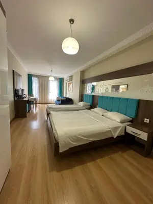 a large bedroom with two beds and a table at Kupeli Hotel in Istanbul