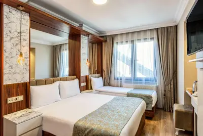 a hotel room with two beds and a window at Kupeli Hotel in Istanbul