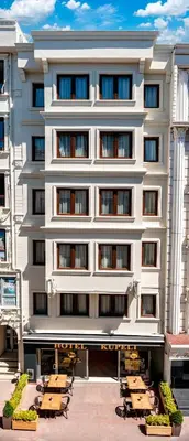 a white building with tables and chairs in front of it at Kupeli Hotel in Istanbul