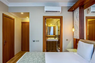a bedroom with a bed and a bathroom with a sink at Kupeli Hotel in Istanbul