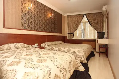 a hotel room with two beds and a television at Turvan Hotel in Istanbul