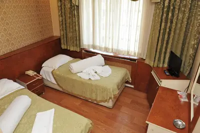 a hotel room with two beds and a television at Turvan Hotel in Istanbul