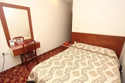 a bedroom with a bed and a dresser and a mirror at Turvan Hotel in Istanbul