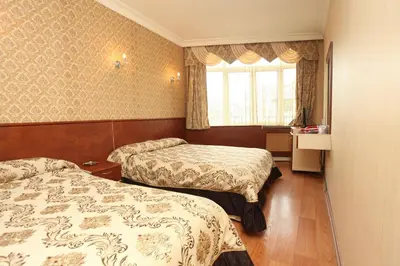 a hotel room with two beds and a window at Turvan Hotel in Istanbul