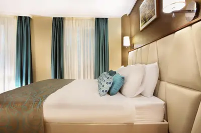 a hotel room with a bed with white and blue pillows at Mard-inn Hotel in Istanbul