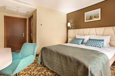 a hotel room with a bed and a blue chair at Mard-inn Hotel in Istanbul