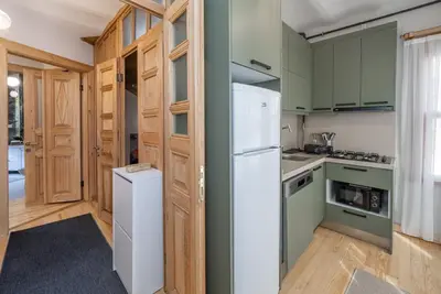 a kitchen with green cabinets and a white refrigerator at acme studio in Istanbul