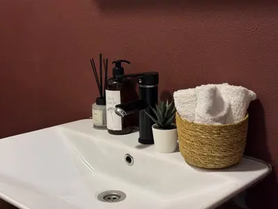 a bathroom sink with toiletries and a basket on it at Stylish Apartment 3 Min to Metro in Istanbul