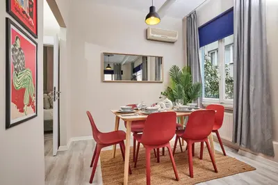 a dining room with a table and red chairs at 2BR Modern Flat in Nişantaşı 3 Min to Metro Full AC in Istanbul