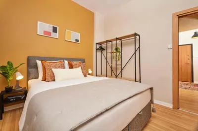 a bedroom with a large bed with orange walls at Prime Nişantaşı 2BR Flat 3-Min Walk to Metro in Istanbul