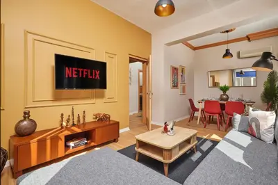 a living room with a couch and a tv at Prime Nişantaşı 2BR Flat 3-Min Walk to Metro in Istanbul
