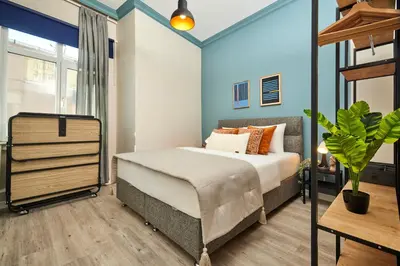 a bedroom with a bed and a blue wall at Central Nişantaşı Stay 2BR Flat AC in All Rooms in Istanbul