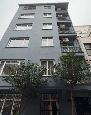 a tall gray building with trees in front of it at Central Nişantaşı Stay 2BR Flat AC in All Rooms in Istanbul
