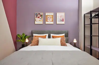 a bedroom with a large bed with purple walls at Comfortable 2BR Flat in Nişantaşı Near Metro in Istanbul