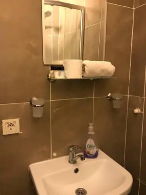 a bathroom with a sink and a mirror and towels at Suite with a kitchen near istiklal street in Istanbul