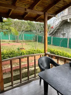 a table and chair on a porch with a view of a field at Ciğ Bungalov Airport in Arnavutköy