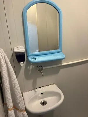 a bathroom with a sink with a blue mirror at Ciğ Bungalov Airport in Arnavutköy