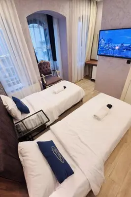 a hotel room with two beds and a flat screen tv at Heart of Pera by Allyon Suite Hotel in Istanbul