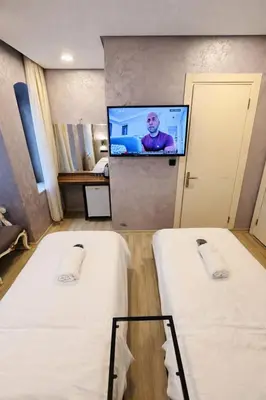 a room with two beds and a flat screen tv at Heart of Pera by Allyon Suite Hotel in Istanbul