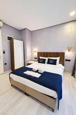 a bedroom with a large bed with blue and white sheets at Heart of Pera by Allyon Suite Hotel in Istanbul