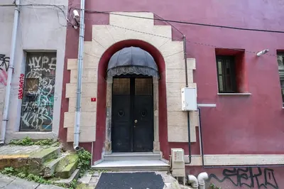 a black door on a pink building with graffiti at Balkon Residence in Istanbul