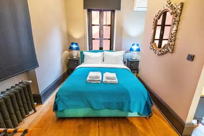 a bedroom with a blue bed with two towels on it at Balkon Residence in Istanbul