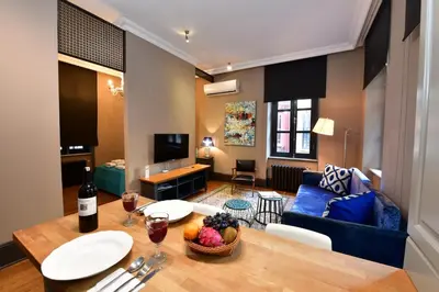 a living room with a table and a blue couch at Balkon Residence in Istanbul