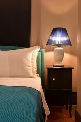 a bedroom with a bed with a lamp on a nightstand at Balkon Residence in Istanbul