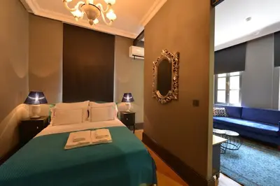 a bedroom with a green bed with a mirror and a couch at Balkon Residence in Istanbul
