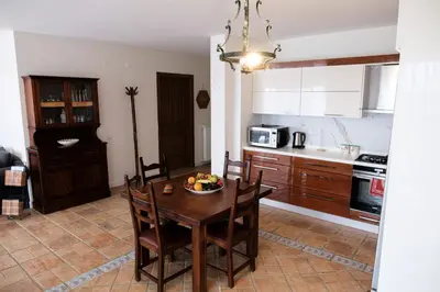 a kitchen with a table with chairs and a bowl of fruit on it at Terrazzo Sapanca - Isıtmalı Havuzlu Villa Süha Fazlı in Sapanca
