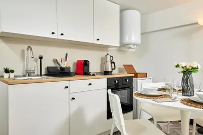 a kitchen with white cabinets and a table with chairs at Stunning Combo Flat in Nisantasi in Istanbul