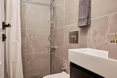 a bathroom with a shower with a toilet and a sink at Bright & Modern 2-Bedroom Flat Near Metro in Istanbul