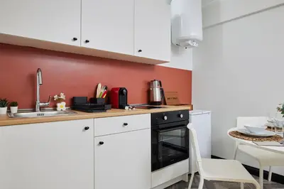 a kitchen with white cabinets and a sink and a stove at Bright & Modern 2-Bedroom Flat Near Metro in Istanbul