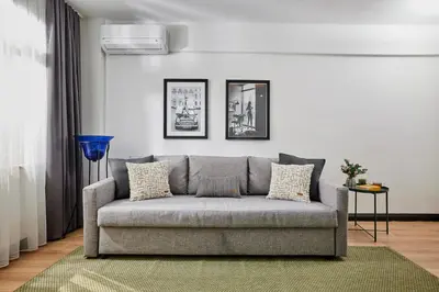 a living room with a gray couch in a room at Stylish 2BR in Central Istanbul 3-Min to Metro in Istanbul