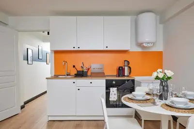 a kitchen with white cabinets and a table with a dining room at Superb Location 3 Min to Metro AC Elevator in Istanbul