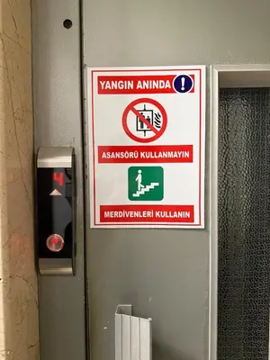 a sign on the wall of a bathroom with a warning sign at Heart of the City 3 Min to Metro 2BR AC in Istanbul