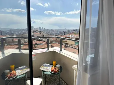 a balcony with two plates of food and a view of a city at Heart of the City 3 Min to Metro 2BR AC in Istanbul
