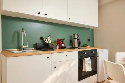 a kitchen with white cabinets and a sink at Heart of the City 3 Min to Metro 2BR AC in Istanbul