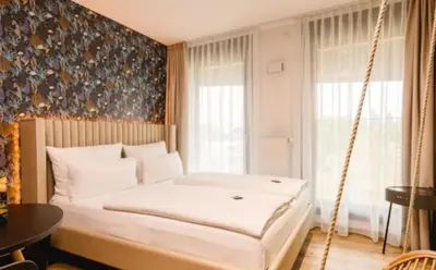 a swinging bed in a room with a window at White garden in Tuzla